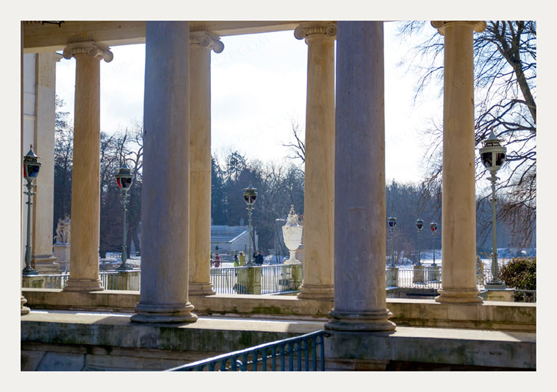 widok przez kolumny na plac przed pałacem Łazienkowskim